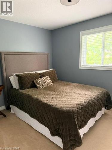Carpeted flooring, window with blinds, ceiling-mounted light fixture, and textured headboard - 5383 Haldimand Crescent, Burlington, ON 