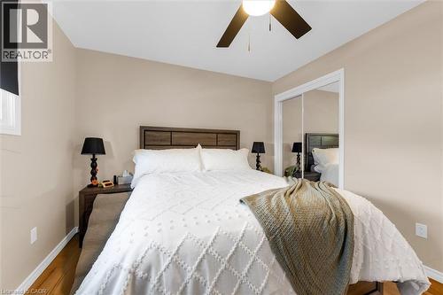 This room features wood flooring, a ceiling fan, and mirrored closet doors - 7506 Jubilee Drive, Niagara Falls, ON 