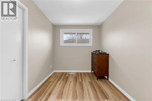 The room features hardwood floors, a single window, and a door with a chrome handle - 7506 Jubilee Drive, Niagara Falls, ON 