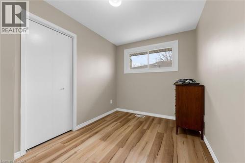 This room features light-colored walls, wide plank flooring, and a window with white trim - 7506 Jubilee Drive, Niagara Falls, ON 