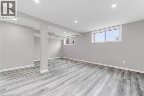 Spacious room with light gray walls, gray wood-style flooring, and recessed lighting - 7506 Jubilee Drive, Niagara Falls, ON 