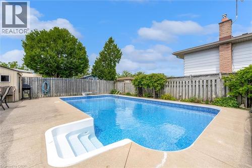 In-ground swimming pool featuring integrated steps and a surrounding concrete patio - 7506 Jubilee Drive, Niagara Falls, ON 