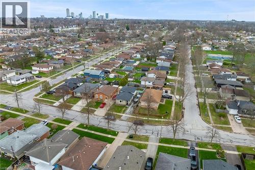 Aerial view showcasing the residential neighbourhood with a variety of homes, tree-lined streets, and a distant city skyline - 7506 Jubilee Drive, Niagara Falls, ON 