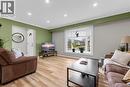 Bright living area featuring light wood flooring, a bay window with blinds, and recessed lighting - 7506 Jubilee Drive, Niagara Falls, ON 