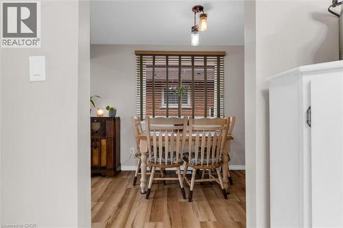 The dining area features wood-look flooring and a window with blinds - 7506 Jubilee Drive, Niagara Falls, ON 