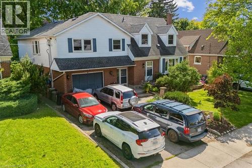 Brick and siding exterior with blue shutters, attached garage, and dormer windows - 80 Maclennan Avenue, Hamilton, ON 