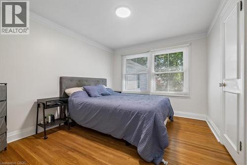 Hardwood flooring, crown molding, white walls, double window with blinds, and a white interior door - 80 Maclennan Avenue, Hamilton, ON 
