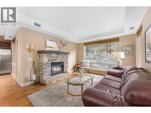 Built-in electric fireplace creates a cozy living space with picture window view. AI enhanced flames. - 2780 Auburn Road Unit# 203, West Kelowna, BC 