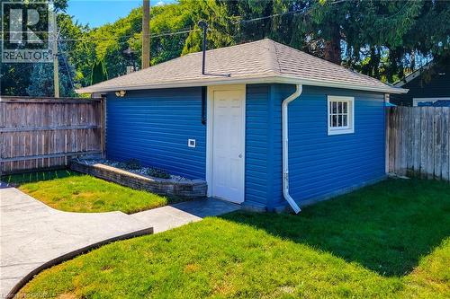 Detached outbuilding with blue siding, a white entry door, and a white-framed window - 19 Thorndale Avenue, St. Catharines, ON 
