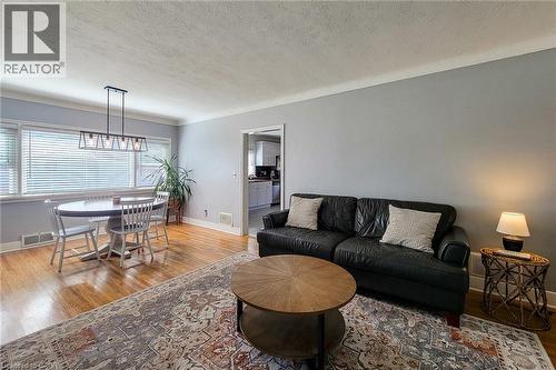 Hardwood flooring, crown molding, white trim, recessed lighting, and a modern rectangular chandelier - 19 Thorndale Avenue, St. Catharines, ON 