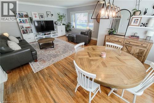 Hardwood flooring throughout, recessed window, built-in shelving, wood-finish console cabinet, and contemporary overhead light fixture - 19 Thorndale Avenue, St. Catharines, ON 