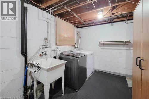 Laundry area featuring a utility sink, exposed ceiling beams, and a built-in storage cabinet - 19 Thorndale Avenue, St. Catharines, ON 