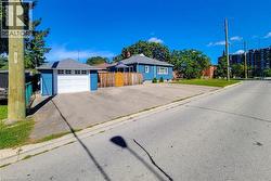 Detached garage with white overhead door, wood fencing, and a blue exterior - 