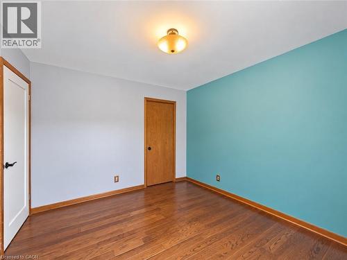 Wood-finish flooring with coordinating wood trim, a ceiling-mounted light fixture, and a solid wood door - 2490 Yarmouth Crescent, Oakville, ON 