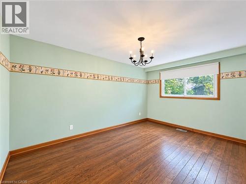 Wood-finish flooring, single window, chandelier light fixture, and decorative wall border - 2490 Yarmouth Crescent, Oakville, ON 