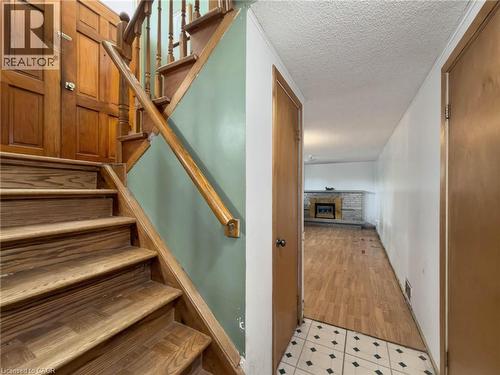 Hardwood staircase with natural wood-finish flooring in the hallway - 2490 Yarmouth Crescent, Oakville, ON 
