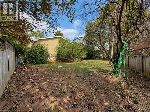 Spacious backyard featuring a substantial mature tree, partial wood fencing, and a partial brick exterior - 2490 Yarmouth Crescent, Oakville, ON 