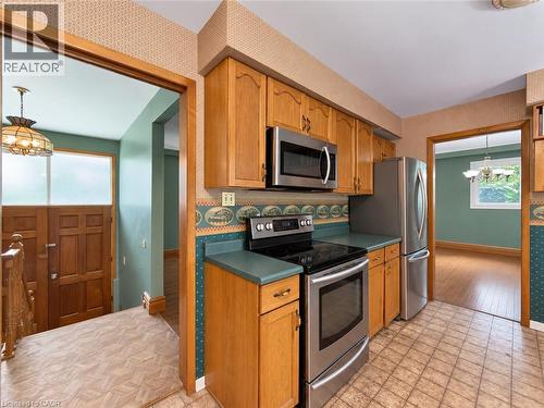 Kitchen featuring wood-finish cabinetry, stainless steel appliances, and a tile floor - 2490 Yarmouth Crescent, Oakville, ON 