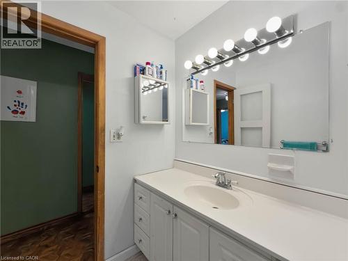 Vanity with integrated sink, chrome faucet, wall-mounted mirror, and overhead strip lighting - 2490 Yarmouth Crescent, Oakville, ON 