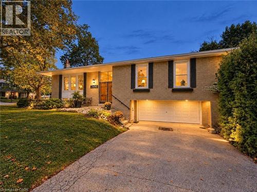 Brick-clad exterior with a two-car garage, concrete driveway, and established landscaping - 2490 Yarmouth Crescent, Oakville, ON 