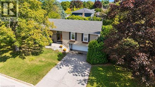 Brick exterior with a gray shingle roof, integrated garage, concrete driveway, and mature landscaping - 2490 Yarmouth Crescent, Oakville, ON 