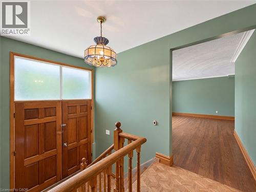 Wood panel double entry doors with transom windows, wood-finish flooring, and a decorative pendant light fixture - 2490 Yarmouth Crescent, Oakville, ON 