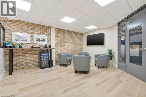 Light wood-finish flooring with exposed brick accent walls - 23 Market Street W, Port Dover, ON 