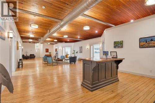 Wood-finish flooring, exposed wood-finish ceiling, exposed metal ductwork, recessed lighting, and wall-mounted sconces - 23 Market Street W, Port Dover, ON 