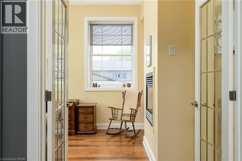 Hardwood flooring, painted walls, white trim, transom windows, and an electric fireplace - 23 Market Street W, Port Dover, ON 