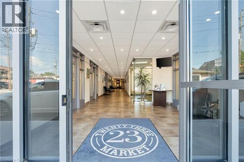 Spacious entry corridor with tiled flooring, recessed lighting, drop ceiling, and glass-paneled entry doors - 23 Market Street W, Port Dover, ON 