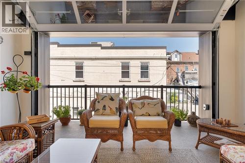 Outdoor patio featuring a black metal railing and a glass paneled overhead door mechanism - 23 Market Street W, Port Dover, ON 