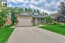Brick and siding exterior featuring a single-car garage, dormer window, and mature landscaping - 423 Poldon Drive, Norwich, ON 