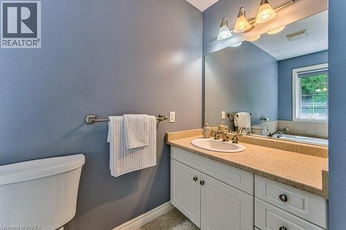 White vanity with cabinet storage, integrated sink, and bronze-finish faucet - 423 Poldon Drive, Norwich, ON 