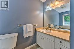 White vanity with cabinet storage, integrated sink, and bronze-finish faucet - 