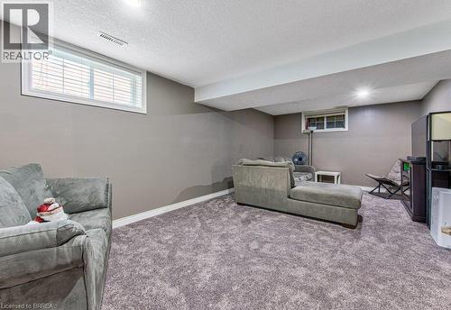 Recessed lighting illuminates a spacious room featuring wall-to-wall carpeting and neutral gray walls - 423 Poldon Drive, Norwich, ON 