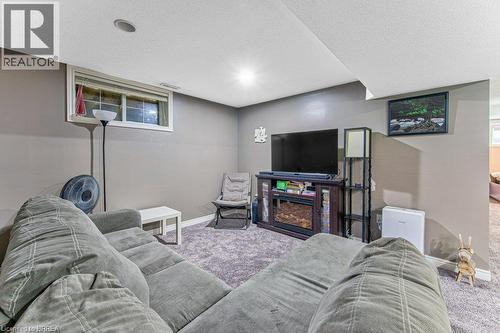 Carpeted entertainment area with recessed lighting, a built-in media console, and a window - 423 Poldon Drive, Norwich, ON 
