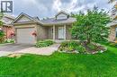 Brick exterior with a peaked roofline, front porch, and an attached garage with a paved driveway - 423 Poldon Drive, Norwich, ON 