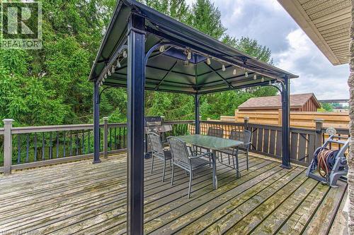 Expansive wooden deck with a built-in gazebo, featuring an attached string lighting system and a privacy fence - 423 Poldon Drive, Norwich, ON 