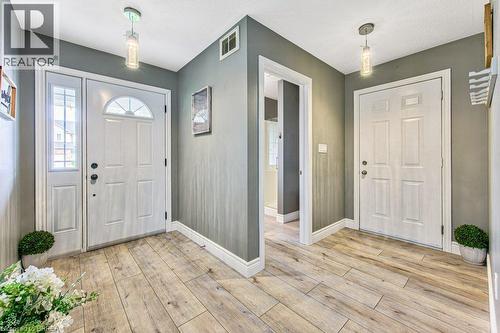 Wood-finish flooring, white trim, recessed lighting, and a white paneled door with an arched transom - 423 Poldon Drive, Norwich, ON 