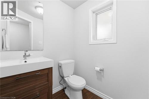 White vanity with integrated sink, wood-finish cabinetry, and chrome fixtures - 449 Exmoor Street, Waterloo, ON 