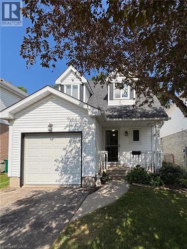 White siding exterior featuring a single-car garage, dormer windows, and a concrete pathway leading to the front entry - 449 Exmoor Street, Waterloo, ON 