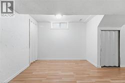 Wood-finish flooring, white walls, and a ceiling-mounted light fixture - 