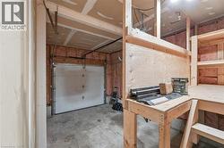 Garage space with an overhead door, concrete flooring, and unfinished walls - 