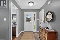 Entryway featuring a white paneled door with sidelight, tile flooring, and a flush mount ceiling light fixture - 