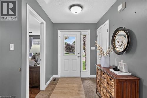 Entryway featuring a white paneled door with sidelight, tile flooring, and a flush mount ceiling light fixture - 515 Woodward Drive, Mount Brydges, ON 