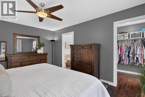 Ceiling fan with integrated lighting, wood-finish flooring, and a walk-in closet with built-in shelving - 515 Woodward Drive, Mount Brydges, ON 