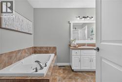Built-in soaking tub with chrome fixtures, complemented by a tiled surround and flooring - 