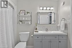 Light gray vanity with ample storage, white countertop, and subway tile backsplash - 