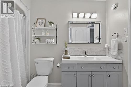 Light gray vanity with ample storage, white countertop, and subway tile backsplash - 515 Woodward Drive, Mount Brydges, ON 