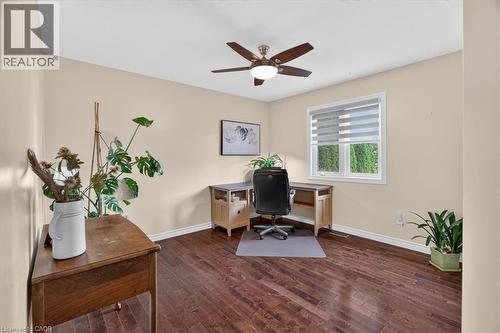 Wood-finish flooring, neutral wall tones, window with horizontal blinds, and a ceiling fan with integrated lighting - 515 Woodward Drive, Mount Brydges, ON 